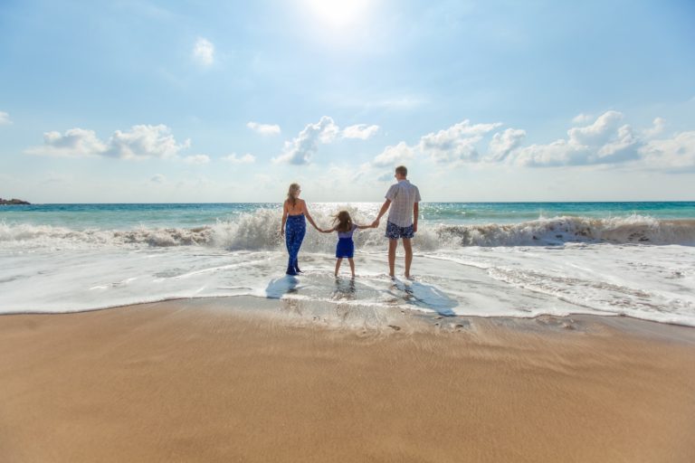 Happy Family Holding Hands on Beach